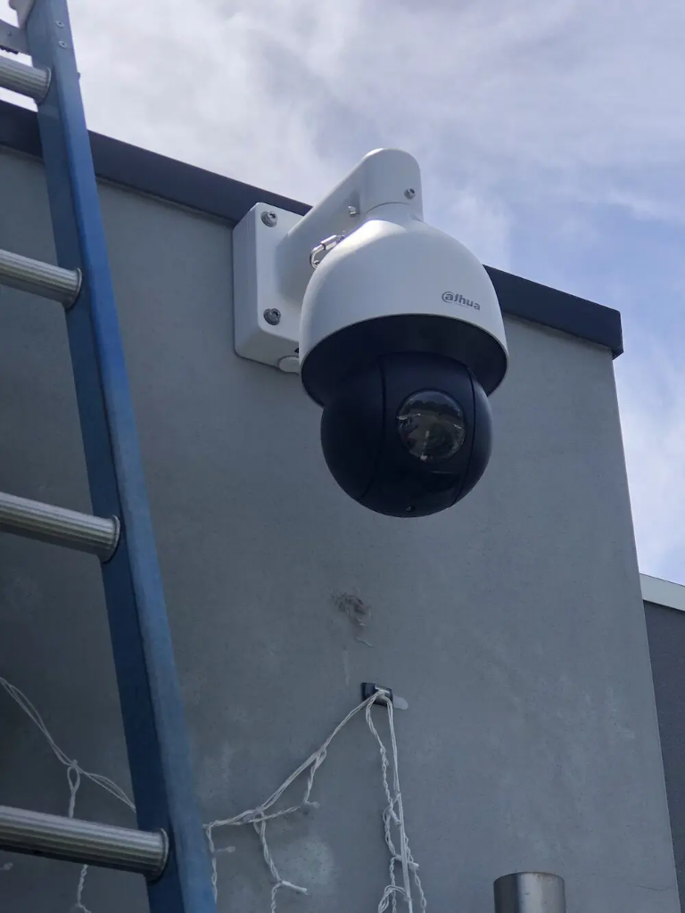 Pan-tilt security camera on a wall bracket, cable fed through the mount out of sight